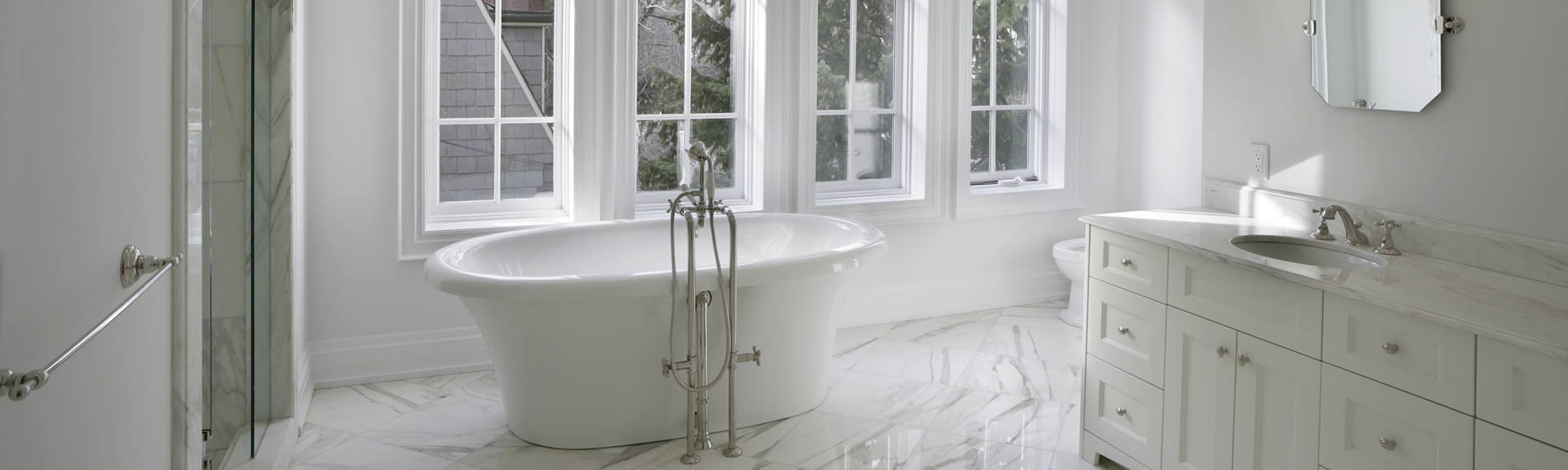 New modern bathroom with free-standing white tub, walk-in shower and white fitted sink unit